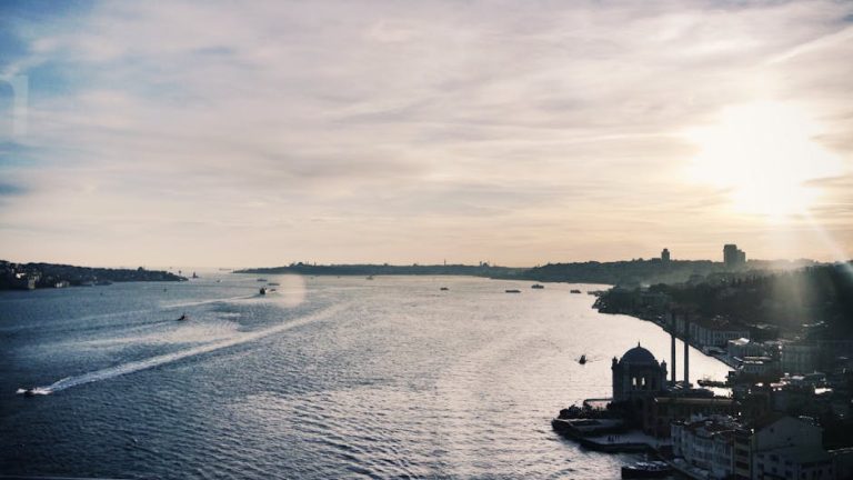 A breathtaking view of Istanbul cityscape and Bosphorus under a sunlit sky, showcasing boats and Ottoman architecture.